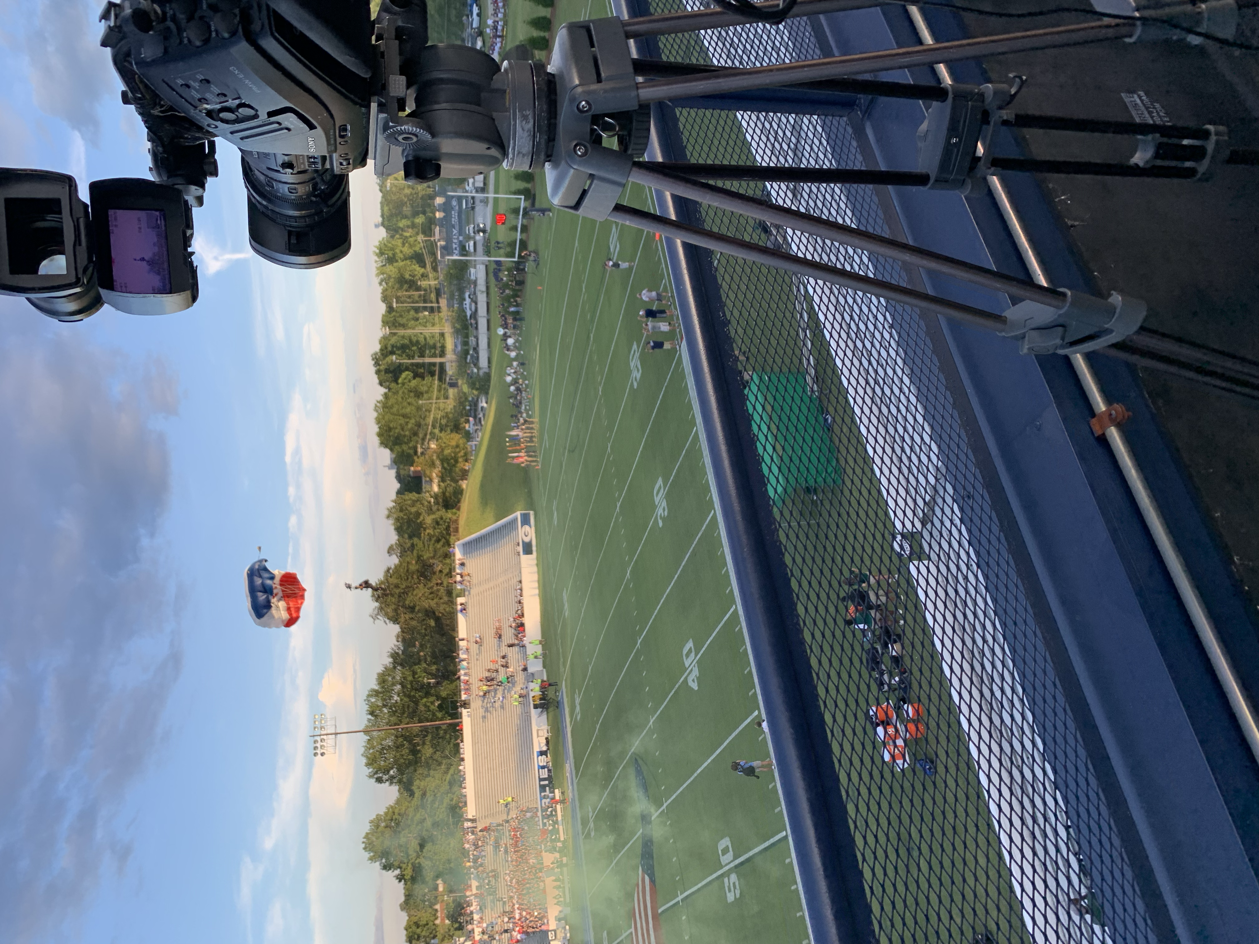 A picture of a parachute landing at a high school football game.